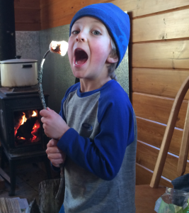 my son stoked about marshmallows roasted via a wood burning stove